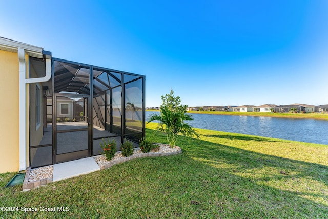 view of yard with a lanai and a water view