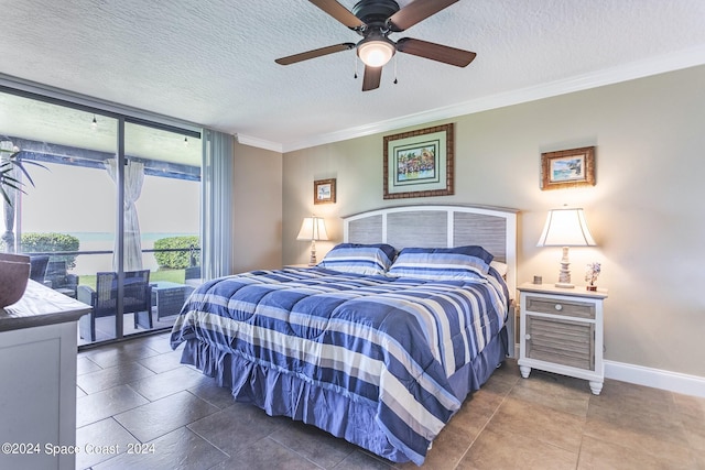 bedroom featuring ornamental molding, ceiling fan, dark tile patterned floors, and a textured ceiling