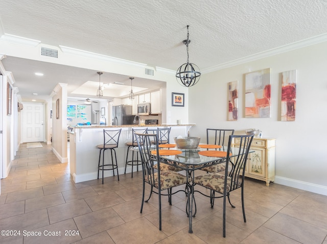 dining area featuring a textured ceiling, tile patterned floors, and crown molding