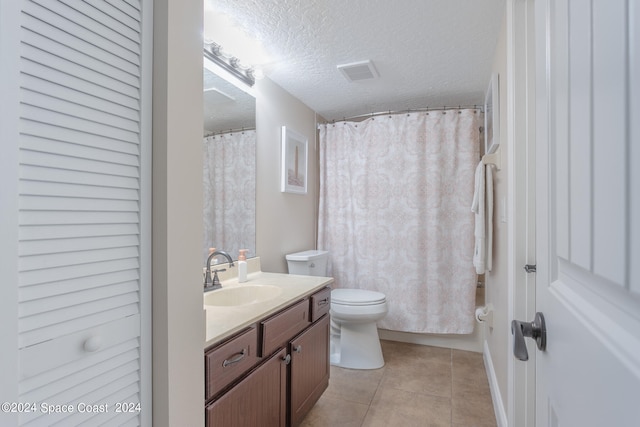 bathroom with curtained shower, vanity, a textured ceiling, toilet, and tile patterned floors