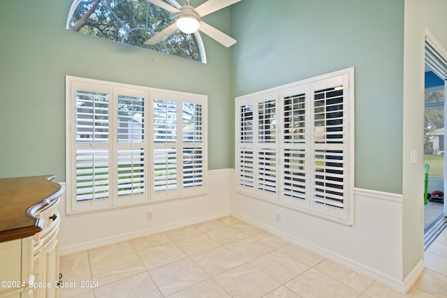 tiled dining area with a high ceiling and ceiling fan