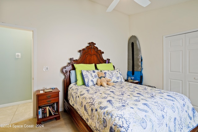 bedroom with ceiling fan, light colored carpet, and a closet