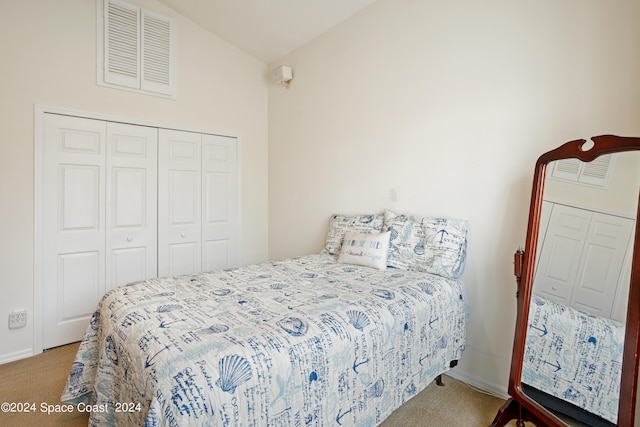 bedroom featuring vaulted ceiling, light carpet, and a closet