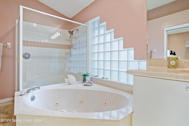 bathroom with shower with separate bathtub, vaulted ceiling, and vanity