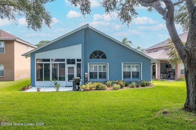 back of property featuring a sunroom and a yard