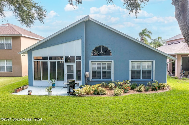 back of house with a sunroom and a yard