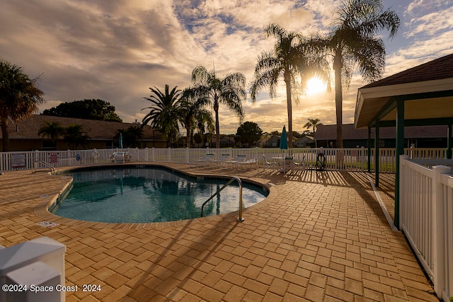 pool at dusk with a patio