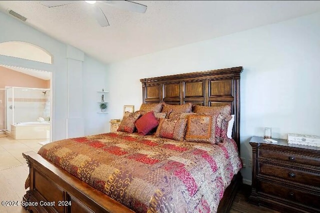 bedroom featuring lofted ceiling, wood-type flooring, ensuite bath, and ceiling fan