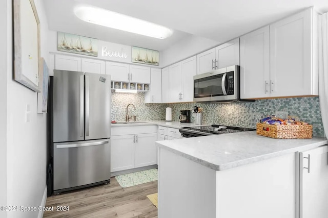 kitchen with appliances with stainless steel finishes, sink, light hardwood / wood-style flooring, and white cabinets