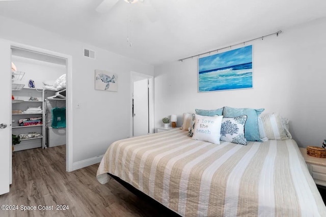 bedroom featuring ceiling fan, a closet, hardwood / wood-style floors, and a spacious closet