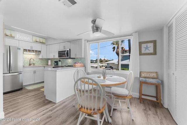 dining room featuring sink, ceiling fan, and light hardwood / wood-style flooring