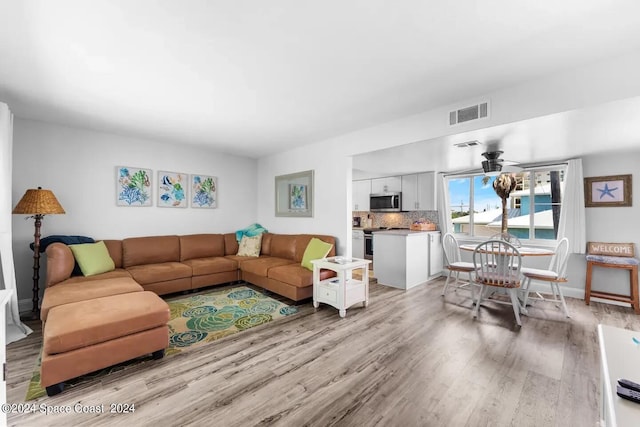 living room featuring light hardwood / wood-style floors and ceiling fan