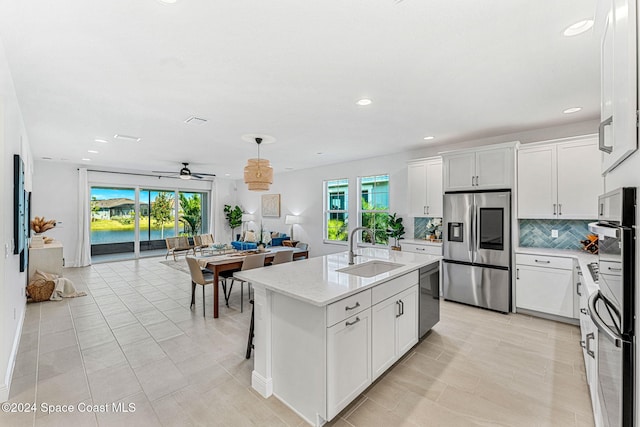 kitchen with white cabinets, stainless steel appliances, and a wealth of natural light