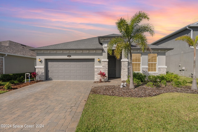 view of front of property featuring a garage and a lawn