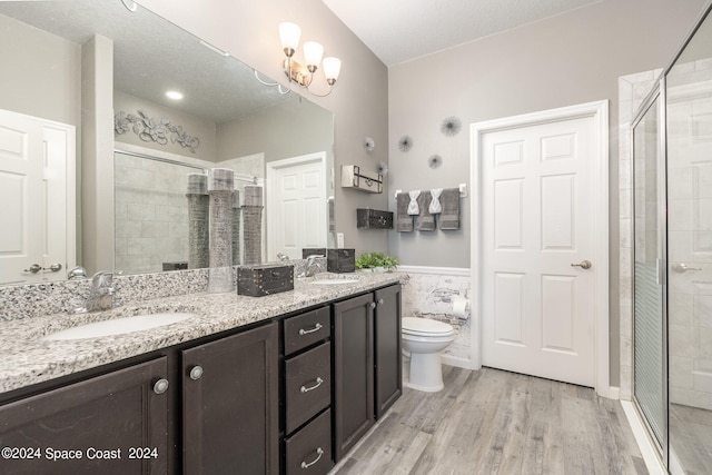 bathroom with vanity, an enclosed shower, a textured ceiling, hardwood / wood-style flooring, and toilet