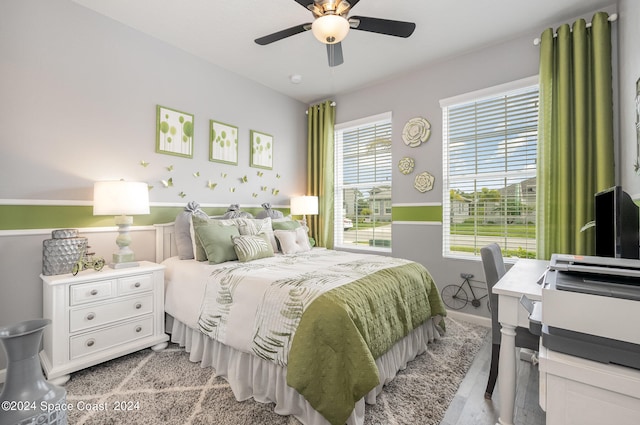 bedroom featuring multiple windows, light wood-type flooring, and ceiling fan