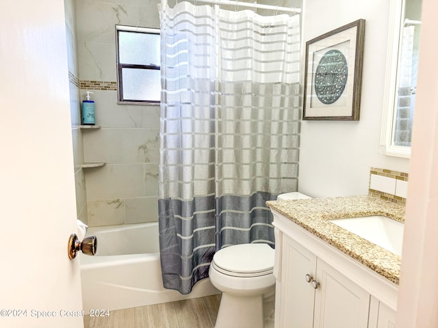 full bathroom with shower / bath combination with curtain, hardwood / wood-style floors, vanity, and toilet