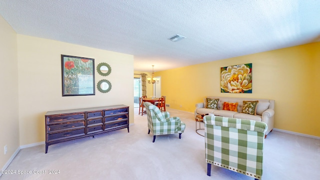 sitting room with a textured ceiling, light carpet, and a notable chandelier