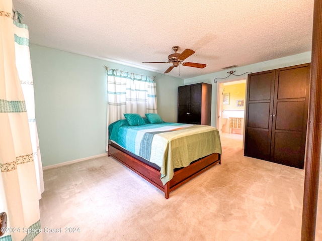 unfurnished bedroom with light carpet, a textured ceiling, and ceiling fan