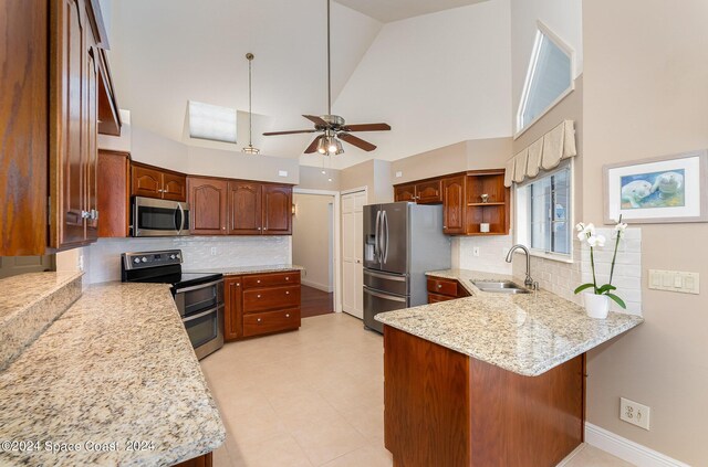 kitchen with sink, kitchen peninsula, high vaulted ceiling, appliances with stainless steel finishes, and ceiling fan