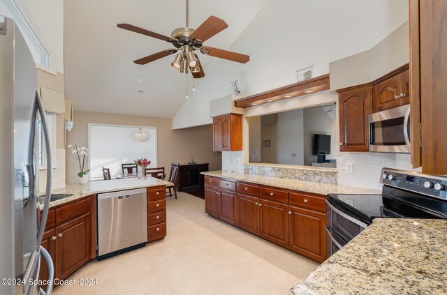 kitchen featuring light stone counters, high vaulted ceiling, backsplash, stainless steel appliances, and ceiling fan