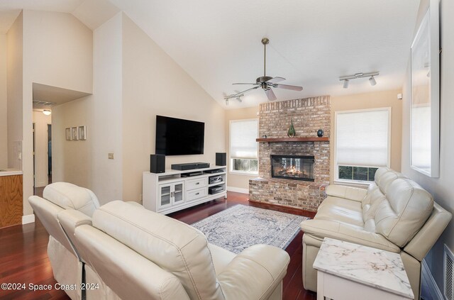 living room with a healthy amount of sunlight, ceiling fan, a fireplace, and dark hardwood / wood-style flooring