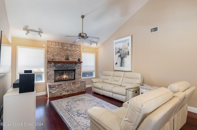 living room featuring a healthy amount of sunlight, dark wood-type flooring, ceiling fan, and a fireplace