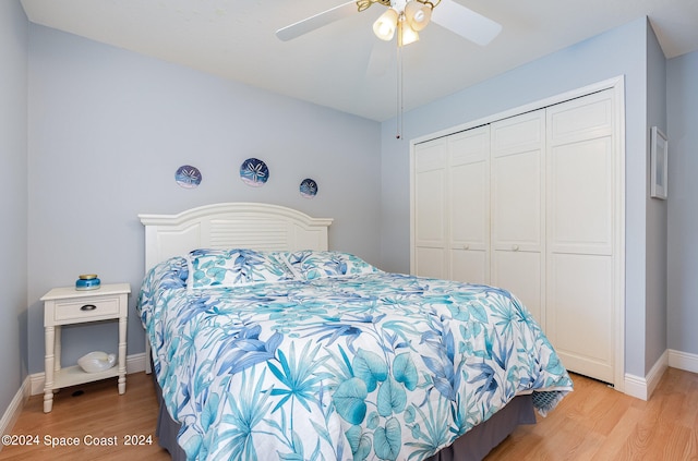 bedroom with light hardwood / wood-style floors, ceiling fan, and a closet