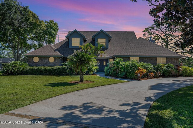 cape cod-style house featuring a lawn