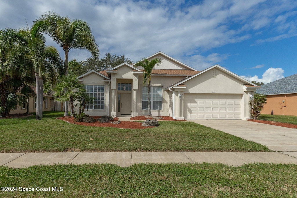 view of front of home with a front lawn and a garage