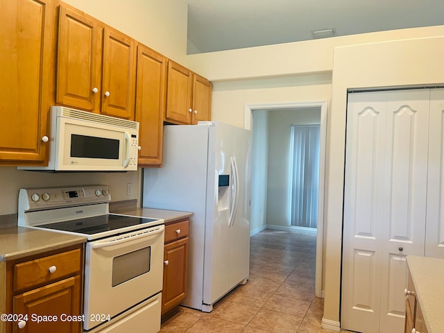 kitchen featuring light tile patterned floors and white appliances