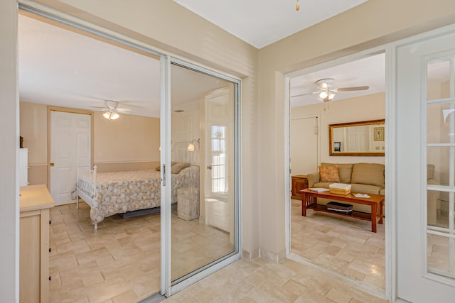 interior space featuring a ceiling fan, stone finish floor, and ensuite bathroom
