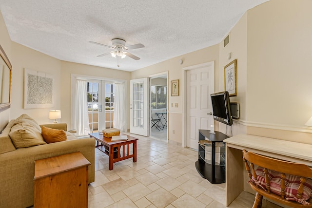 living room with visible vents, a ceiling fan, a textured ceiling, and french doors