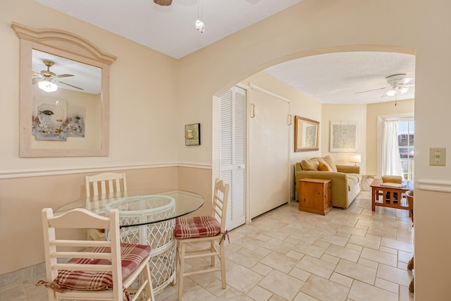 dining area featuring a ceiling fan and arched walkways