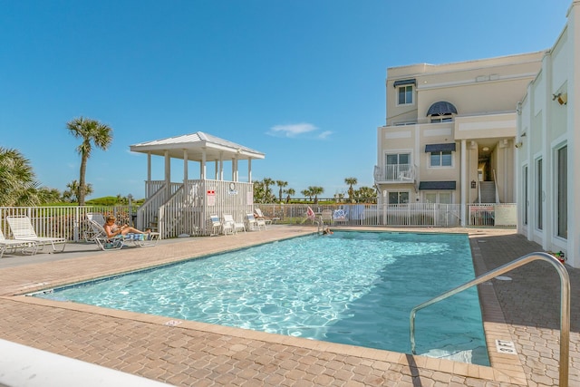 community pool featuring fence and a patio area