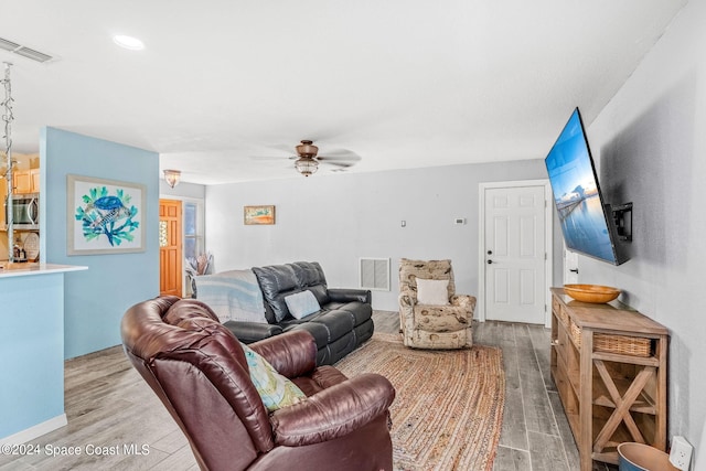 living room featuring hardwood / wood-style floors and ceiling fan