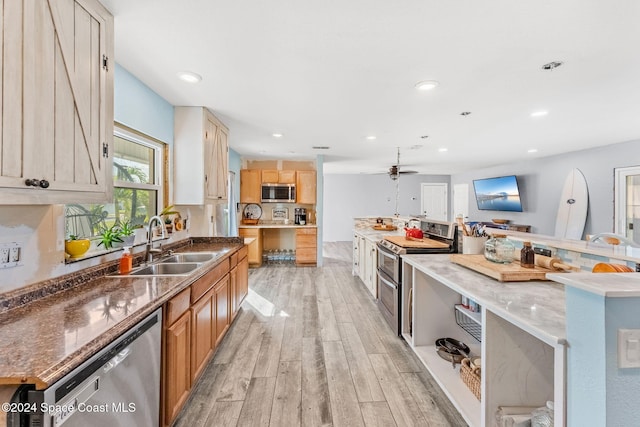 kitchen with light hardwood / wood-style flooring, light brown cabinetry, stainless steel appliances, sink, and stone counters