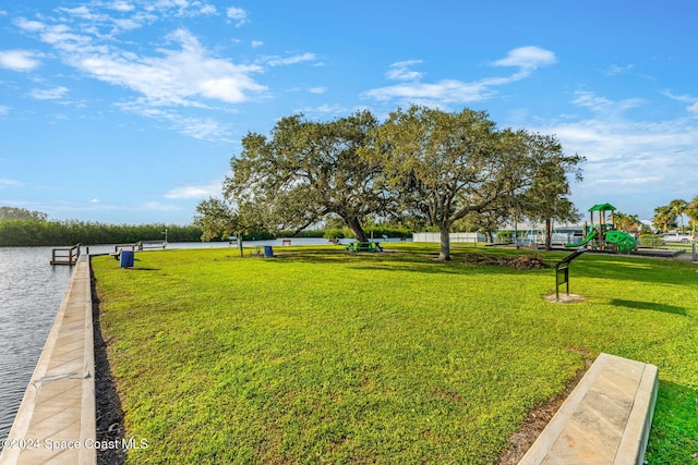 view of home's community with a water view and a lawn