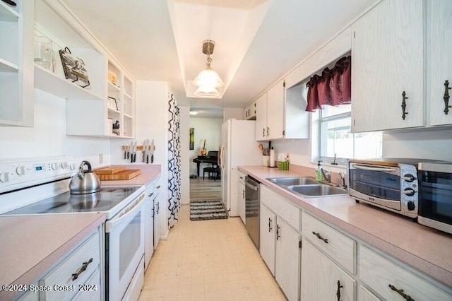 kitchen featuring pendant lighting, stainless steel appliances, sink, and white cabinets