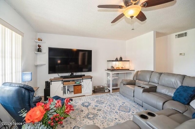 living room featuring ceiling fan, a textured ceiling, and hardwood / wood-style floors