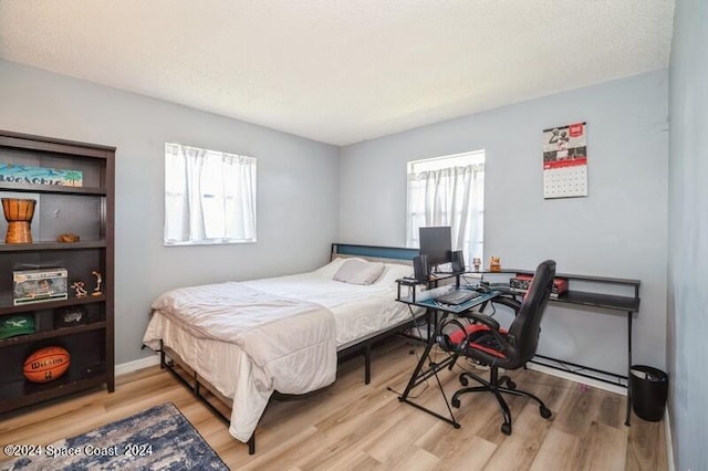 bedroom featuring multiple windows and light wood-type flooring