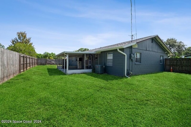 rear view of house featuring a yard and central air condition unit