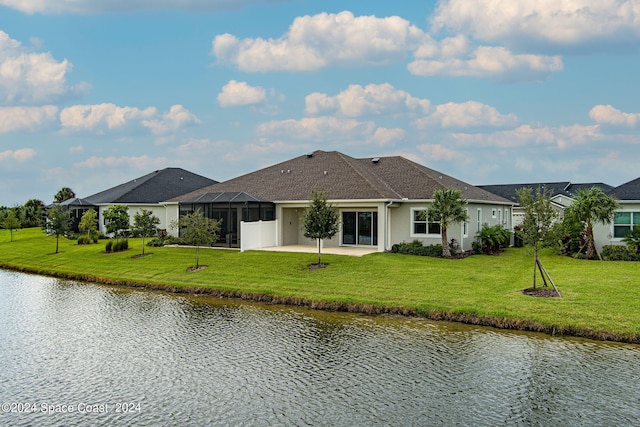 rear view of property featuring glass enclosure, a water view, and a yard