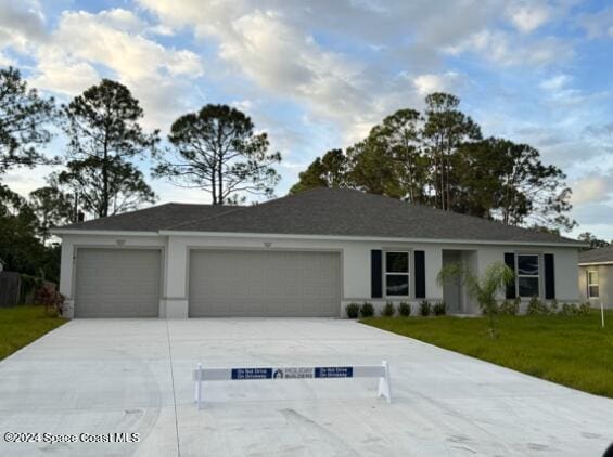 ranch-style home with a garage and a front yard