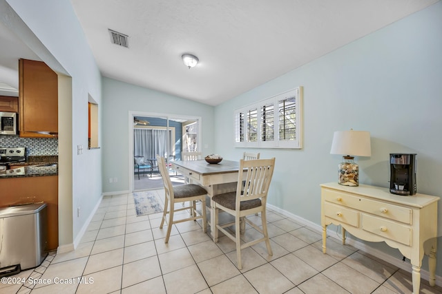 dining room with lofted ceiling and light tile patterned floors