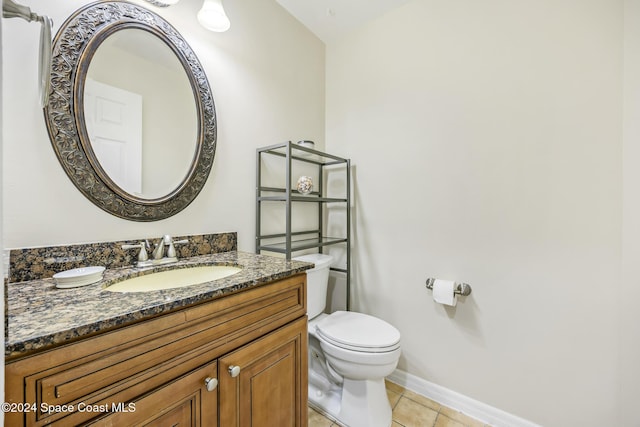 bathroom with tile patterned flooring, vanity, and toilet