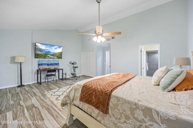 bedroom with hardwood / wood-style floors, a closet, high vaulted ceiling, and ceiling fan