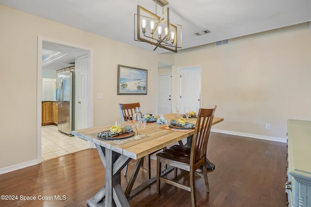 dining space with light wood-type flooring and an inviting chandelier