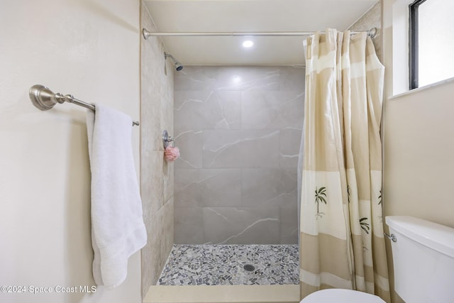 bathroom featuring a shower with shower curtain and toilet