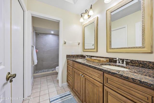 bathroom featuring tiled shower, vanity, tile patterned floors, and toilet